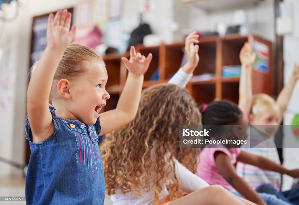 Shot of a group of children sitting in class I'm always excited to come to class Preschool Stock Photo