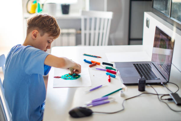 istock Preschool Boy Having Craft Lesson With Clay At Home Using Laptop 1397849330