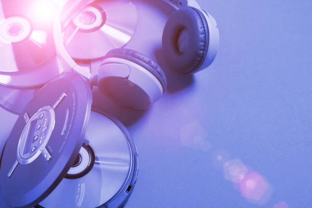 istock Personal compact portable CD player disks headphones blue neon background, Top view 1397850069