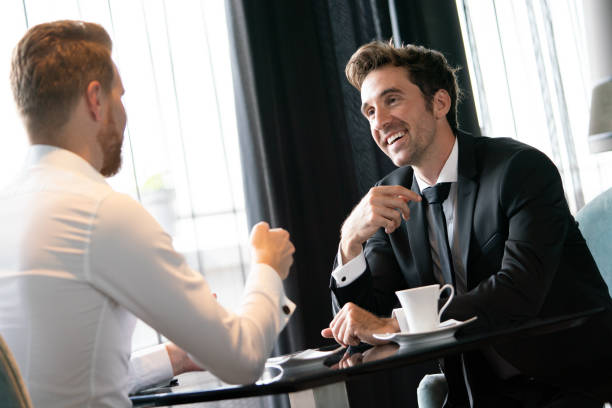 istock Successful businessman smiling while discussing with partner during meeting at coffee break 1397850396