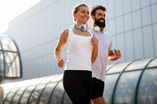 Fitness sport health people and lifestyle concept. Happy fit smiling couple running outdoors