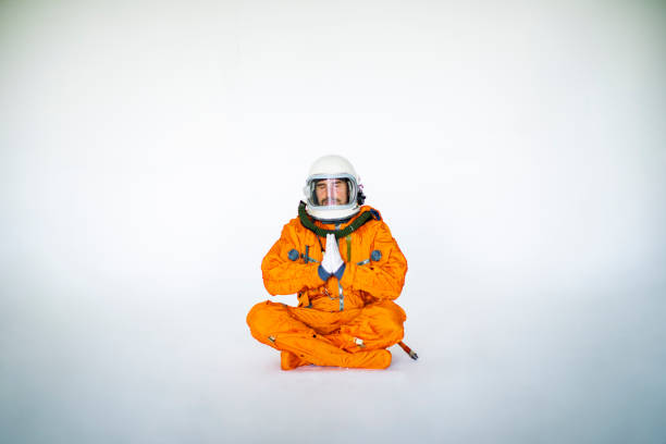 istock Young Man In Space Suit Practising Yoga 1397855973