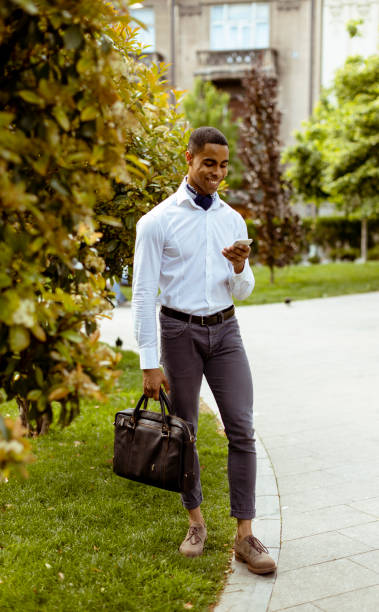 istock Young African American businessman using a mobile phone while walking on a a street 1397859246