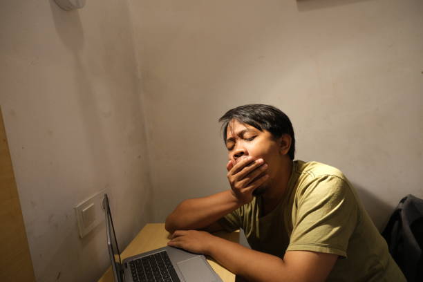 mężczyzna z azji południowo-wschodniej czuje się senny podczas pracy w swoim pokoju - southeast asian ethnicity men laptop image type zdjęcia i obrazy z banku zdjęć