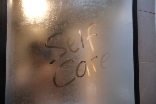 text of self care written on dewy mirror at bathroom - condensation steam window glass imagens e fotografias de stock