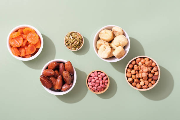 Mix of dried fruits and nuts in bowls - symbols of judaic holiday Tu Bishvat. green background Mix of dried fruits and nuts in bowls - symbols of judaic holiday Tu Bishvat. green background. orthodox judaism photos stock pictures, royalty-free photos & images