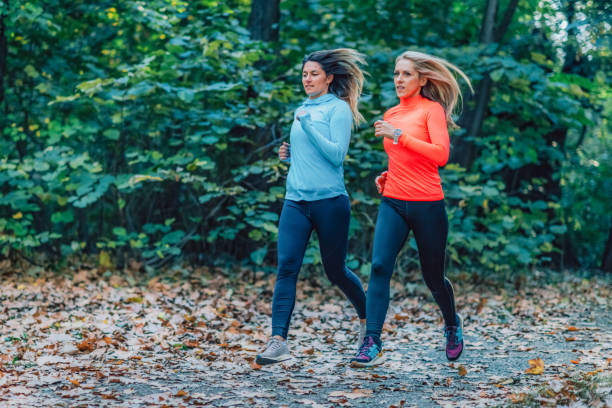 istock Women Jogging Outdoors In A Public Park. Autumn, Fall. 1397862398