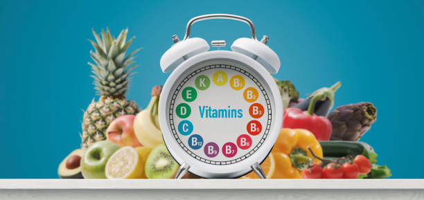wecker mit vitaminen und frischem grün - vitamin c vitamin a vitamin e vegetable stock-fotos und bilder