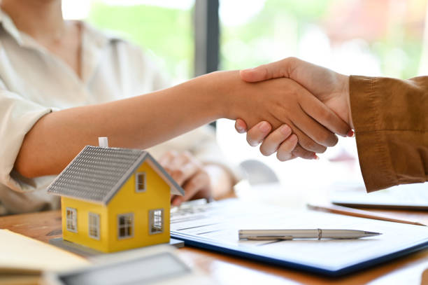 istock Female real estate agent shaking hands with her potential client 1397862991
