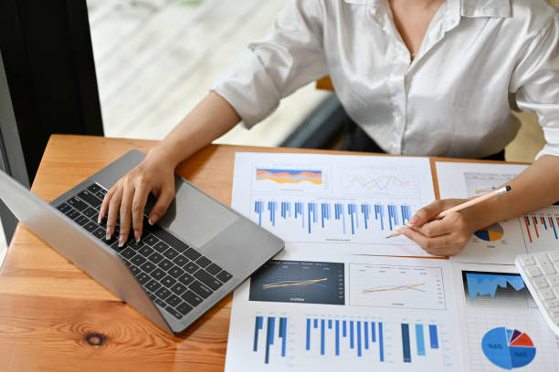 istock Top view, Female financial accountant using laptop computer and examining report. 1397863697