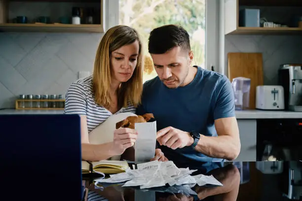 Photo of Man And Woman Checking Payment Bills In The Kitchen At Home. Planning Family Budget