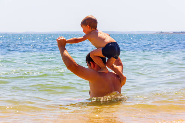 Kerch, Russia - 12 August 2019: dad and son have fun at the sea on a summer day