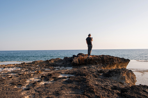 Man with mobile phone on the coast.