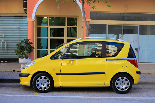 Saranda, Albania - 19 october, 2020: Yellow car parking on the street in Saranda, Albania