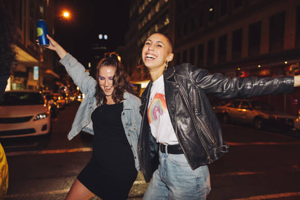 Celebrating with dance Celebrating with dance. Two happy female friends dancing cheerfully while crossing a street in the city. Two vibrant young women laughing and having a good time on a weekend night. ladies night stock pictures, royalty-free photos & images