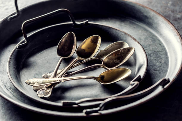 Antique trays with spoons on a rustic table.