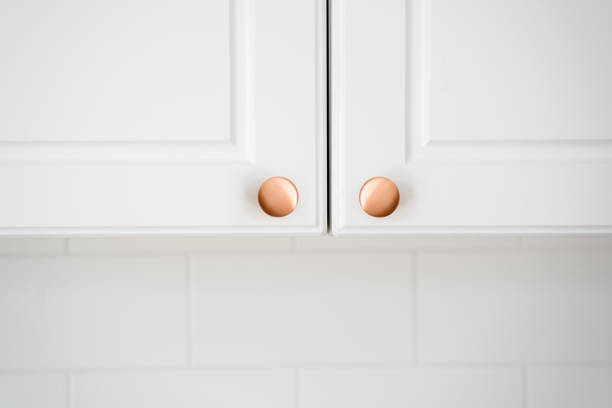 istock Two small round copper door knob on white kitchen cabinet 1397869807