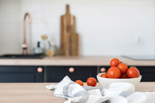 Closeup of raw tomatoes on table in bright kitchen interior design. Healthy food products. Cooking at home. Healthy nutrition. Seasonal vegetable