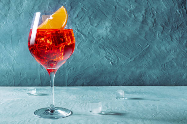 Aperol cocktail with an orange slice, a side view on a blue background stock photo