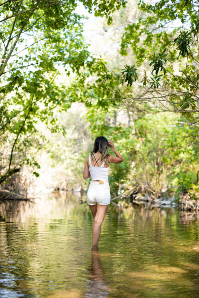 istock Young Beautiful Woman is Walking in the River 1397872009