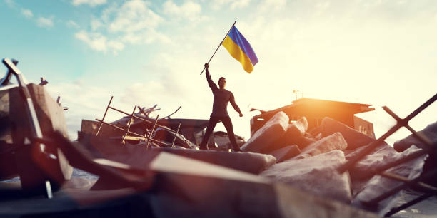 Man with Ukraine flag on city ruin. Ukrainian victory stock photo