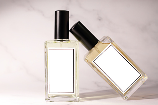 Perfume is held by a persons hand in a store isle