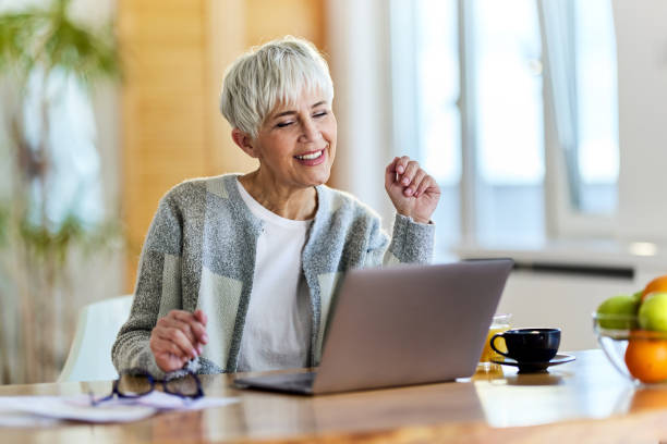 istock Happy senior woman using computer at home. 1397875212