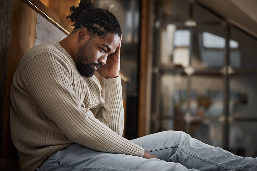 Thoughtful African American man having problems while relaxing at home.