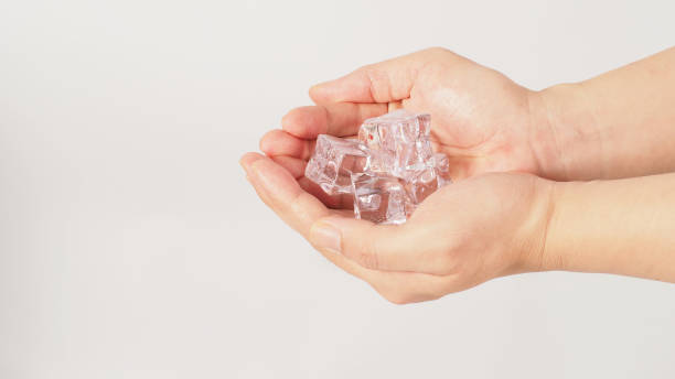istock Two hands is holding ice cubes on white background.