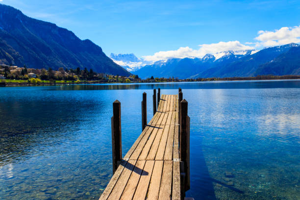 Wooden pier overlooking the Alps and Lake Geneva in Switzerland stock photo