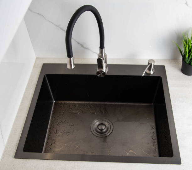 istock Modern kitchen sink with detergent dispenser and faucet with curved movable hose. Kitchen faucet with curved spout against white porcelain tiles, beautiful interior 1397884813