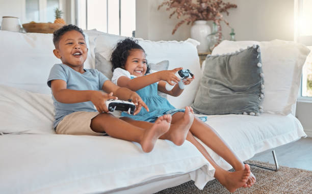 집에서 소파에서 비디오 게임을하는 형제 자매의 샷 - video game family child playful 뉴스 사진 이미지