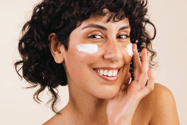 istock Woman applying cosmetic moisturizer on her face 1397884856