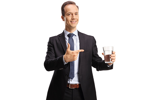 Businessman holding a glass of water and pointing isolated on white background