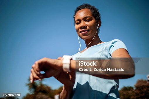 istock Smiling woman checking heart rate after sports training 1397887678