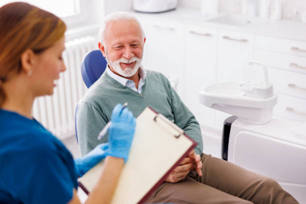 dentista che prende le cartelle cliniche dal paziente - dentists chair immagine foto e immagini stock