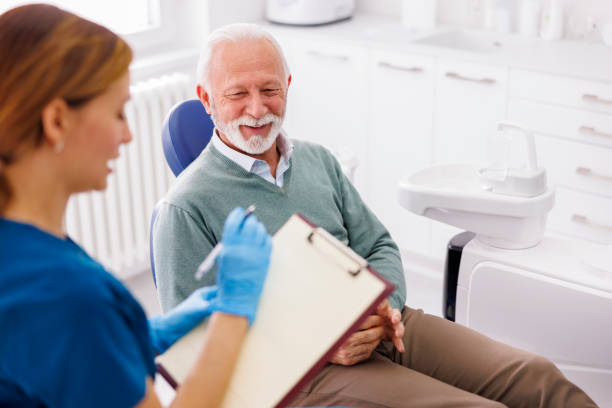 Dentist taking medical records from patient Senior man having dental checkup at dentist office, consulting with doctor about necessary procedures, dentist taking medical records dentists chair stock pictures, royalty-free photos & images
