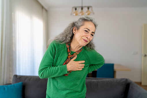 Senior Woman Suffering from Chest Pain at Home