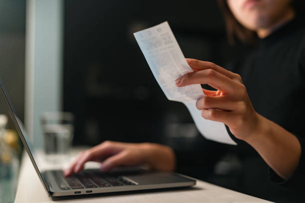 Close-up photo of woman`s hands construction industry doing financial planning and checking receipts at home A close-up photo of a woman`s hands doing financial planning and checking receipts at home. receipt stock pictures, royalty-free photos & images