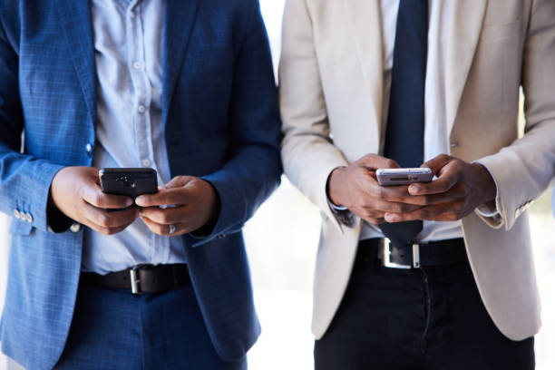 istock Two young businessmen using smart phones in an office 1397890724