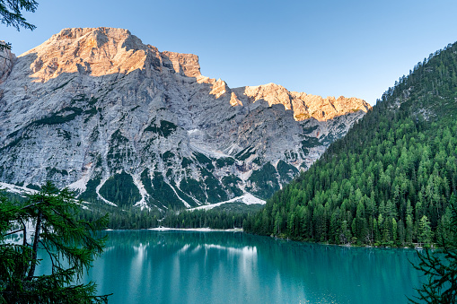 Silent morning in mountain lake Lago di Braies, surrounded by mountains and pine forests.