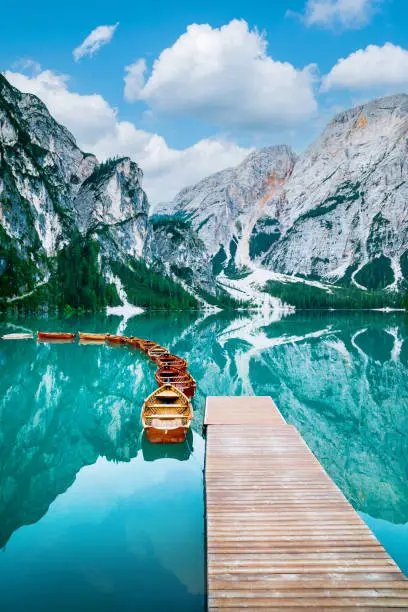 Wooden boats on the lake, surrounded by mountains. Silent morning on the mountain lake "Lago di Braies"