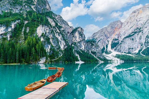 Wooden boats on the lake, surrounded by mountains. Silent morning on the mountain lake 