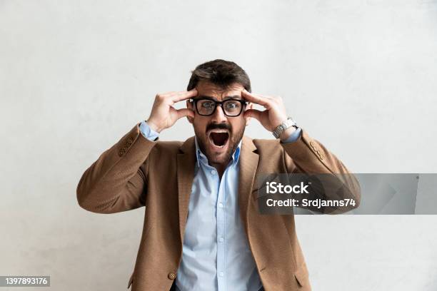 Young Office Worker Mad By Stress Screaming Frustrated Business Man Yelling From Anger And Frustration After He Got Fired And Lost His Job Unemployment Concept Stock Photo - Download Image Now