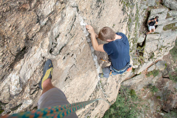istock High angle view of young man climbing vertical rock face 1397894612