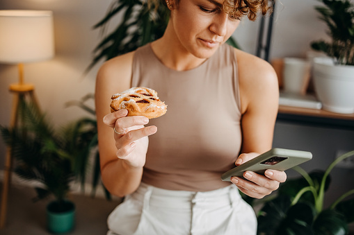 Woman with pastry and phone