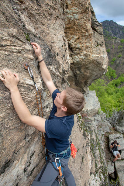 istock High angle view of young man climbing vertical rock face 1397897657