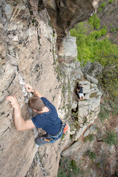 istock High angle view of young man climbing vertical rock face 1397897747