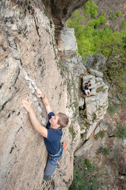 istock High angle view of young man climbing vertical rock face 1397897762