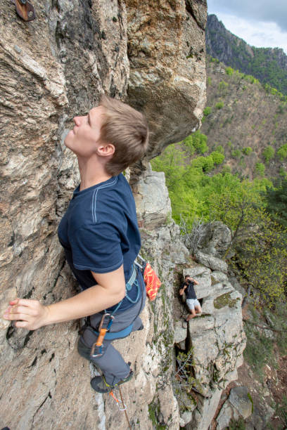 istock High angle view of young man climbing vertical rock face 1397897897